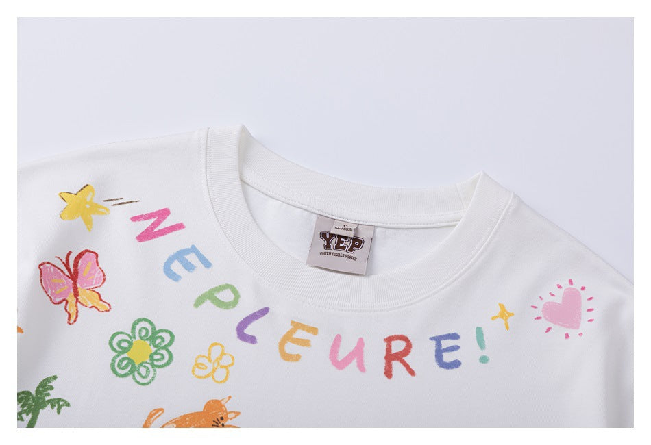 Close-up of the white T-shirt's crew neckline, sewn-in label, and colorful lettering and doodle print.