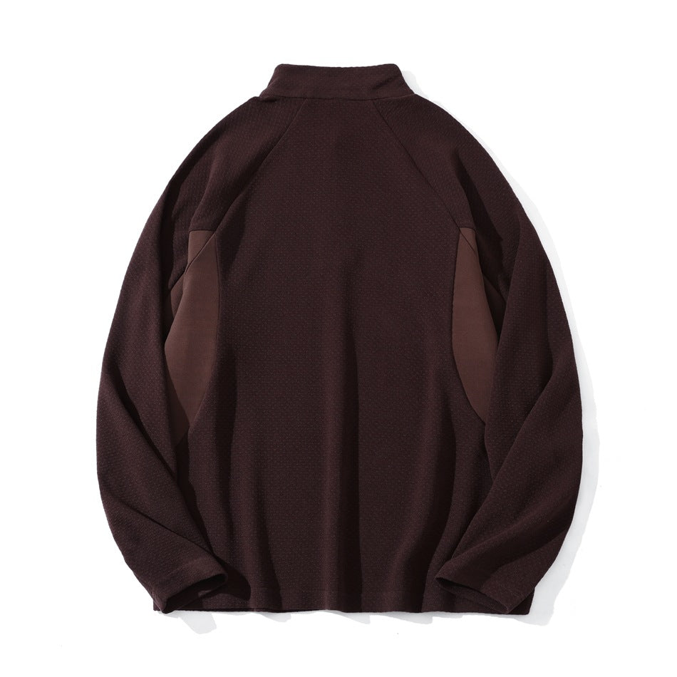 Burgundy pullover laid flat, back view, with a stand collar, raglan sleeves, and contrasting side panels.