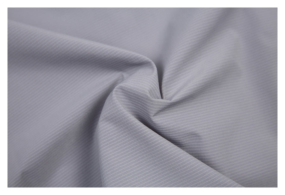Close-up of the fine, subtle pinstripe texture on light gray garment fabric.