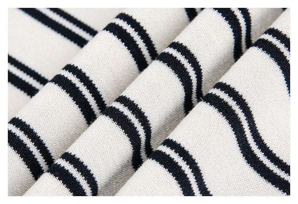 Close-up of folded ivory knit fabric with narrow black stripes.