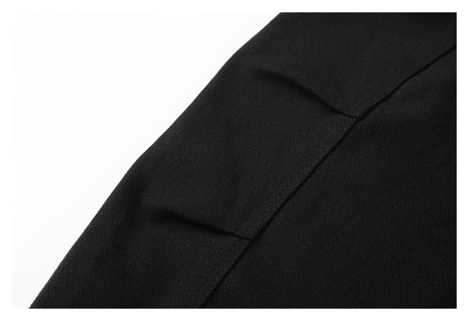Close-up of black garment fabric showing a raised seam and panel construction.