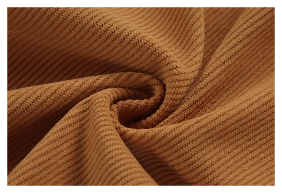 Close-up of caramel-brown ribbed fabric folded into soft drapes.