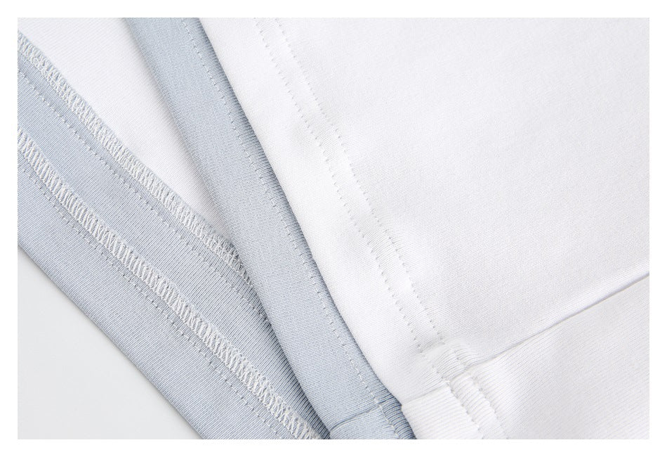 Close-up of white and pale blue shirt fabric showing inner overlock stitching and seams.