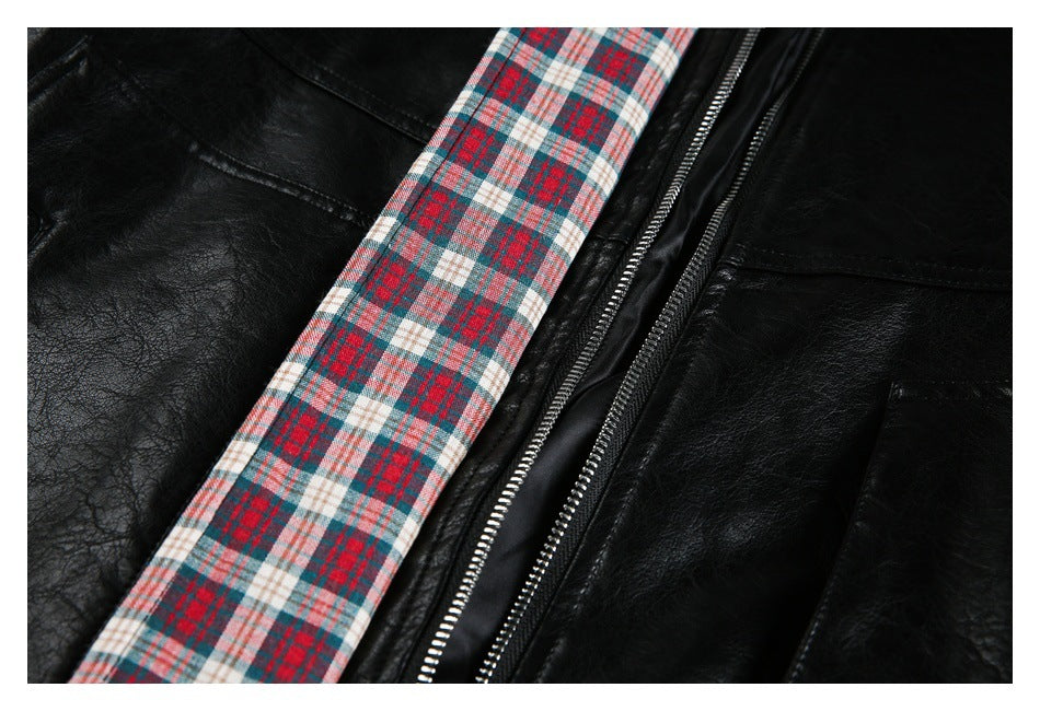 Close-up of the jacket's red, teal, and cream plaid trim beside a silver zipper and black panels.