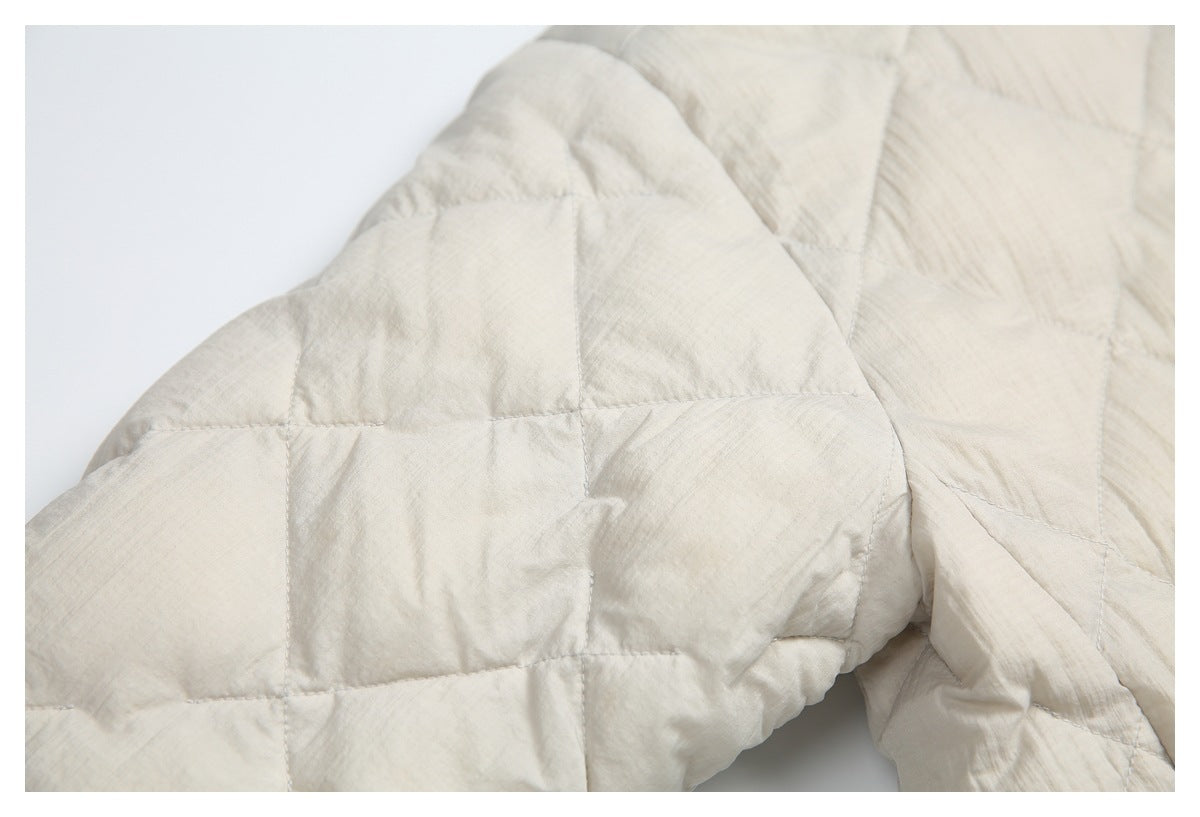 Close-up of the cream jacket's quilted sleeve and stitched panels.