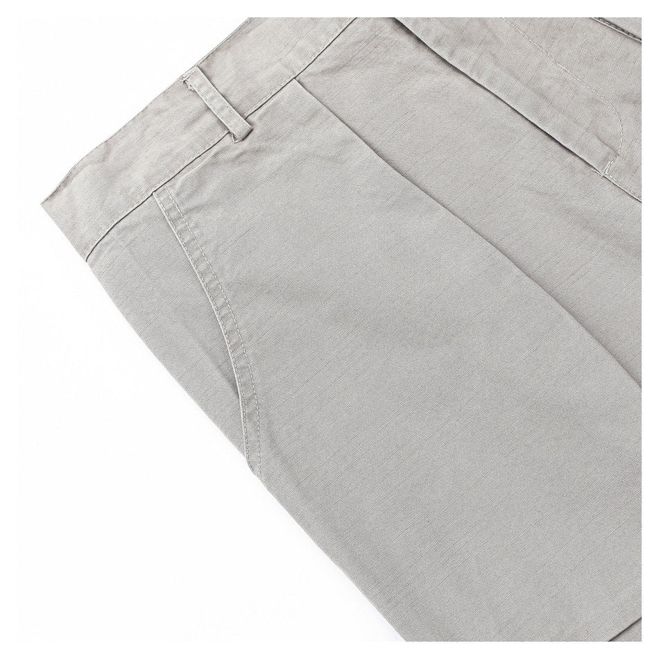 Close-up of a front pocket opening, belt loop, and waistband on the light gray trousers.