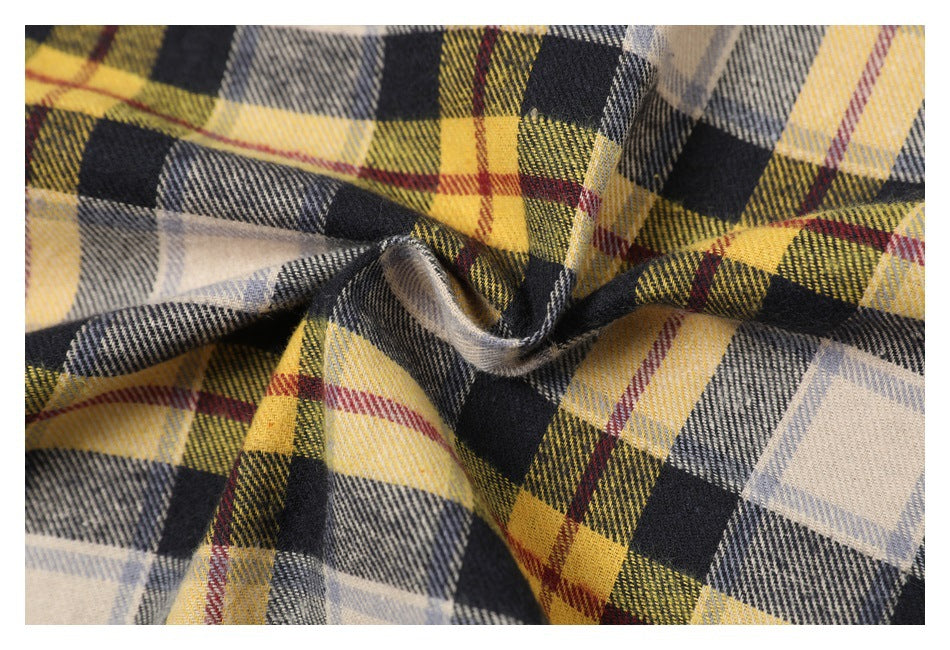 Close-up of gathered fabric with a yellow, black, cream, and red plaid pattern.