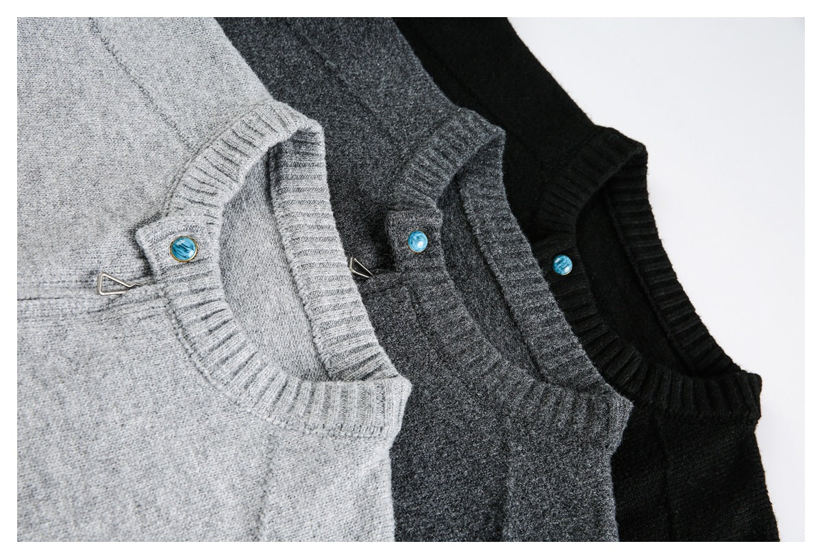 Close view of three knit sweaters in light gray, charcoal, and black, with ribbed necklines and blue buttons.