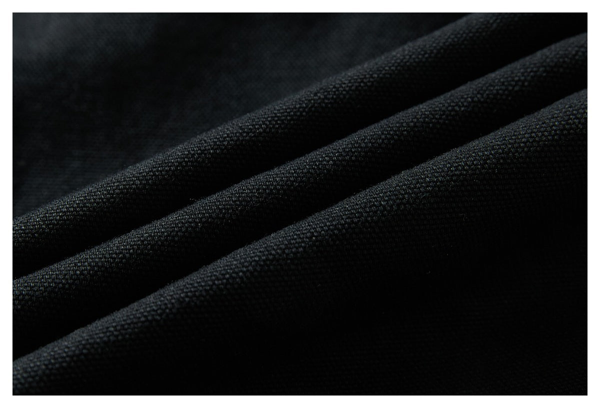 Macro view of the textured black fabric, draped in soft folds.