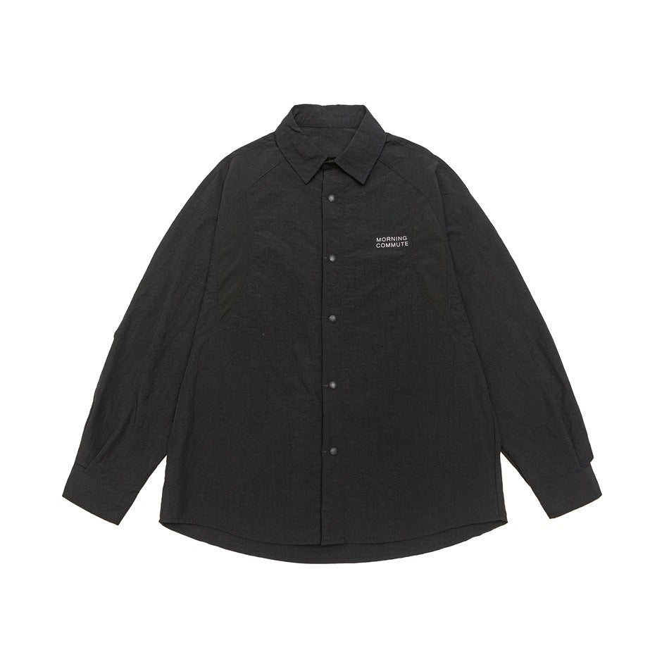 Black long-sleeve button-front shirt with pointed collar, raglan sleeves and small chest print, flat lay