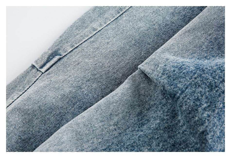 Close-up of faded blue denim panels and a stitched seam.