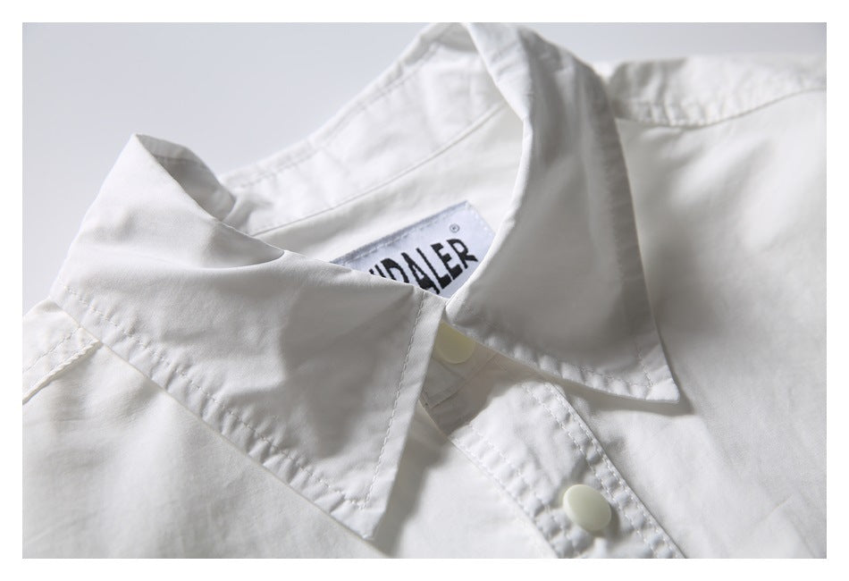 Close-up of the white shirt's pointed collar, snap-button placket, and inner brand label.