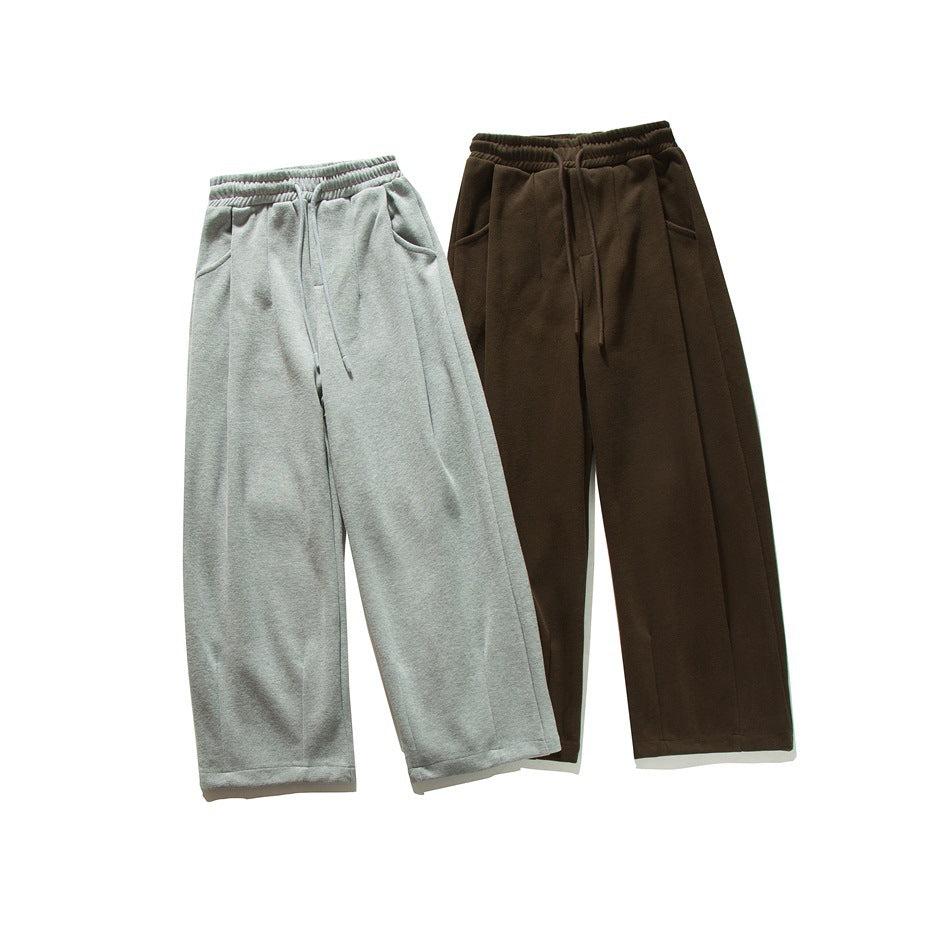 Front view of two wide-leg sweatpants with elastic waistbands and drawstrings, in light gray and dark brown.