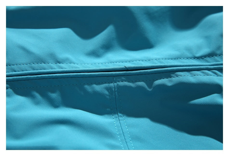 Close-up of stitching and a horizontal seam on the turquoise jacket.