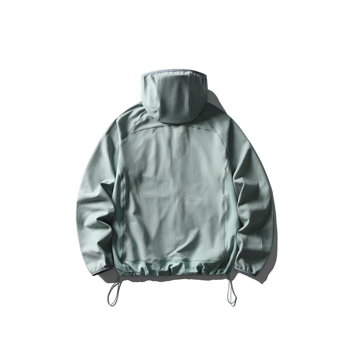 Back view of a pale sage-green hooded jacket laid flat, with raglan seams, elastic cuffs and hem, and hanging drawcords.