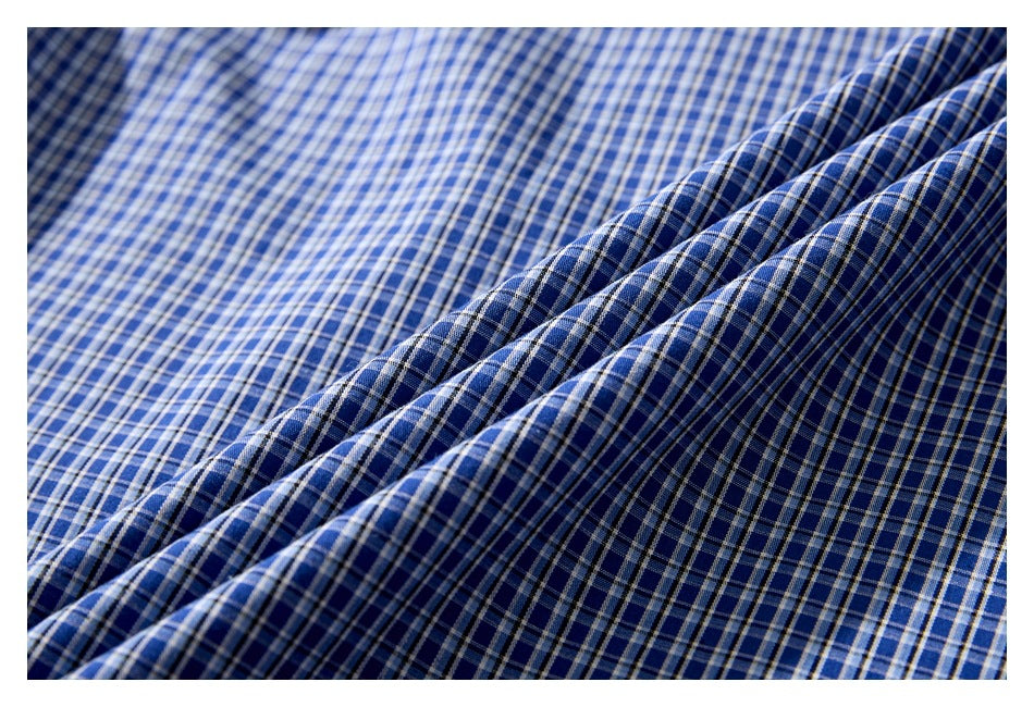Close-up of blue plaid shirt fabric draped in folds, highlighting the checked pattern.