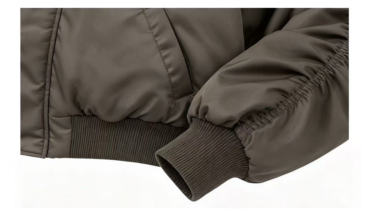 Close-up of the jacket's ribbed sleeve cuff, gathered sleeve, and waistband.