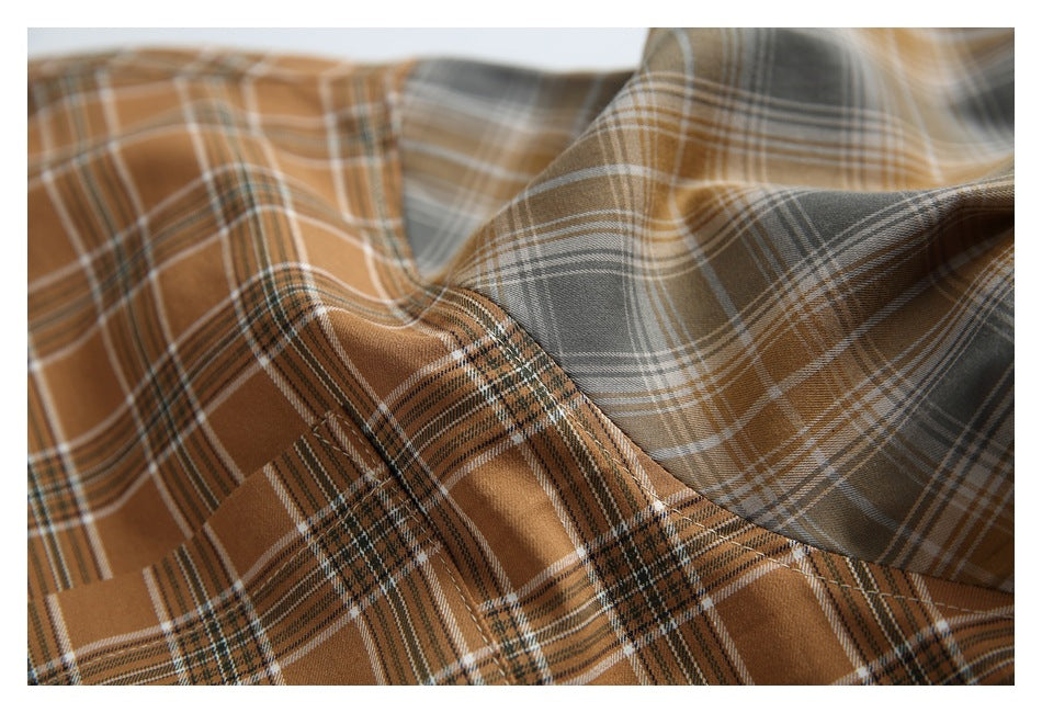 Close-up of draped brown and gray plaid shirt fabric, showing the intersecting stripe pattern.