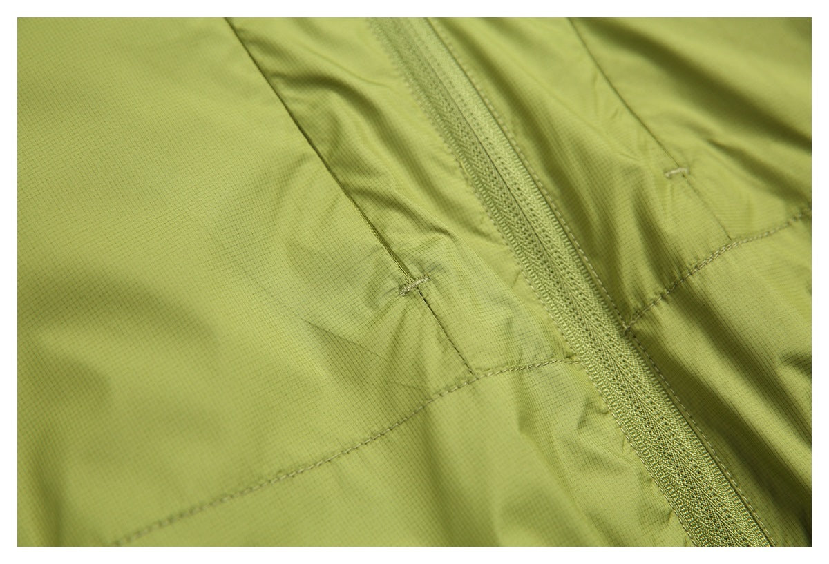 Close-up of a lime-green zipper and reinforced stitched seams on the garment.