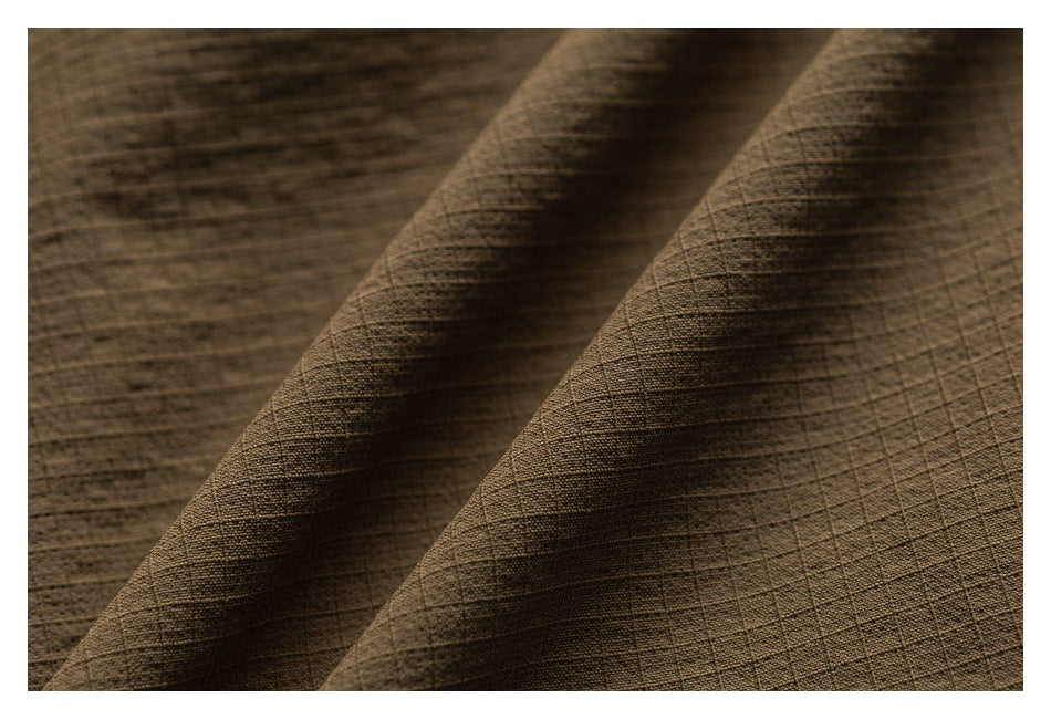Close-up showing the brown garment fabric’s fine woven grid texture and folds.