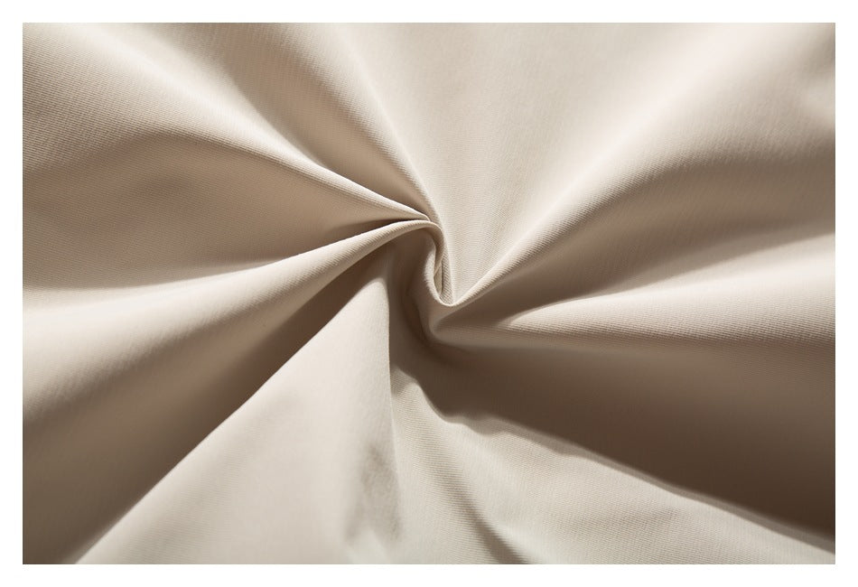 Close-up of beige garment fabric arranged in soft folds.