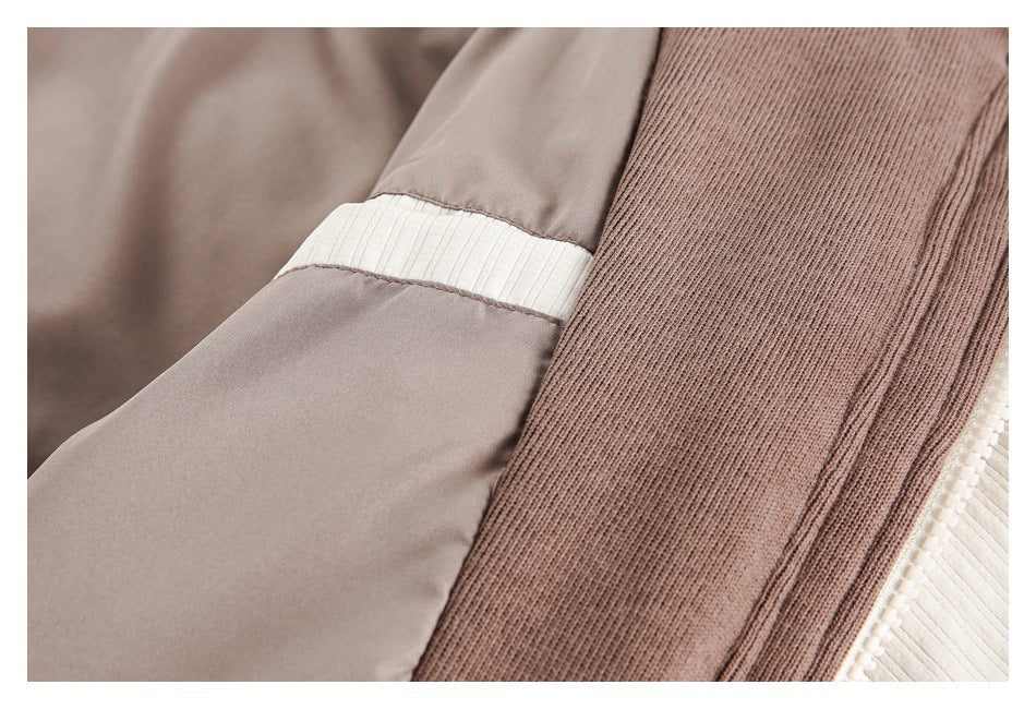 Close-up of a taupe sleeve with an ivory band beside brown ribbed trim.