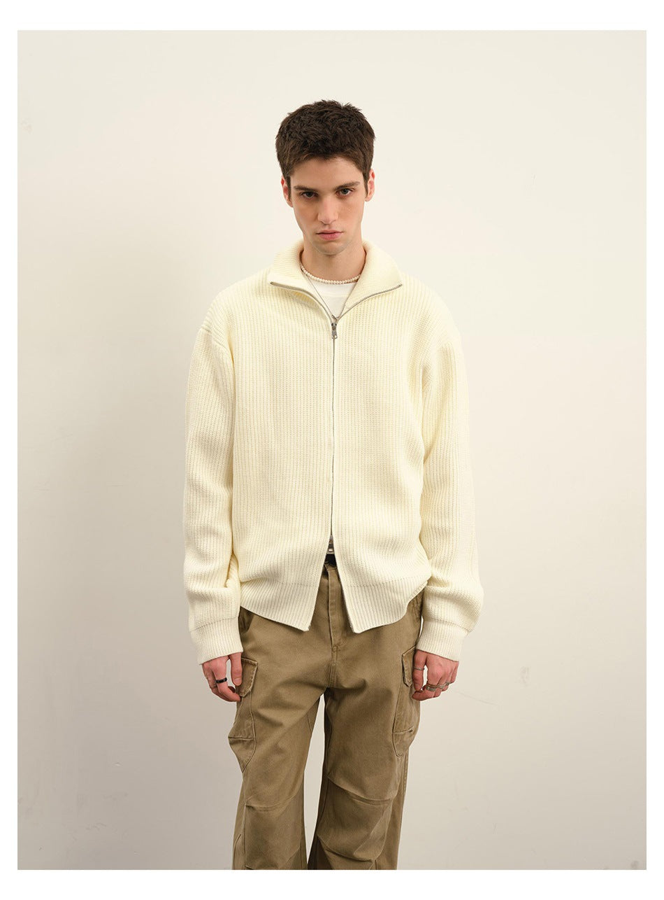 Front view of a model wearing an ivory ribbed zip cardigan with a stand collar.