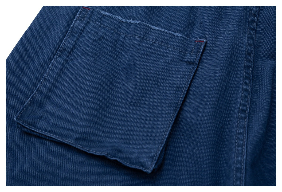 Close-up of a dark blue garment pocket with visible stitching and a small red bartack.