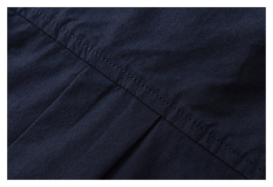 Close-up of diagonal double stitching across navy garment fabric.