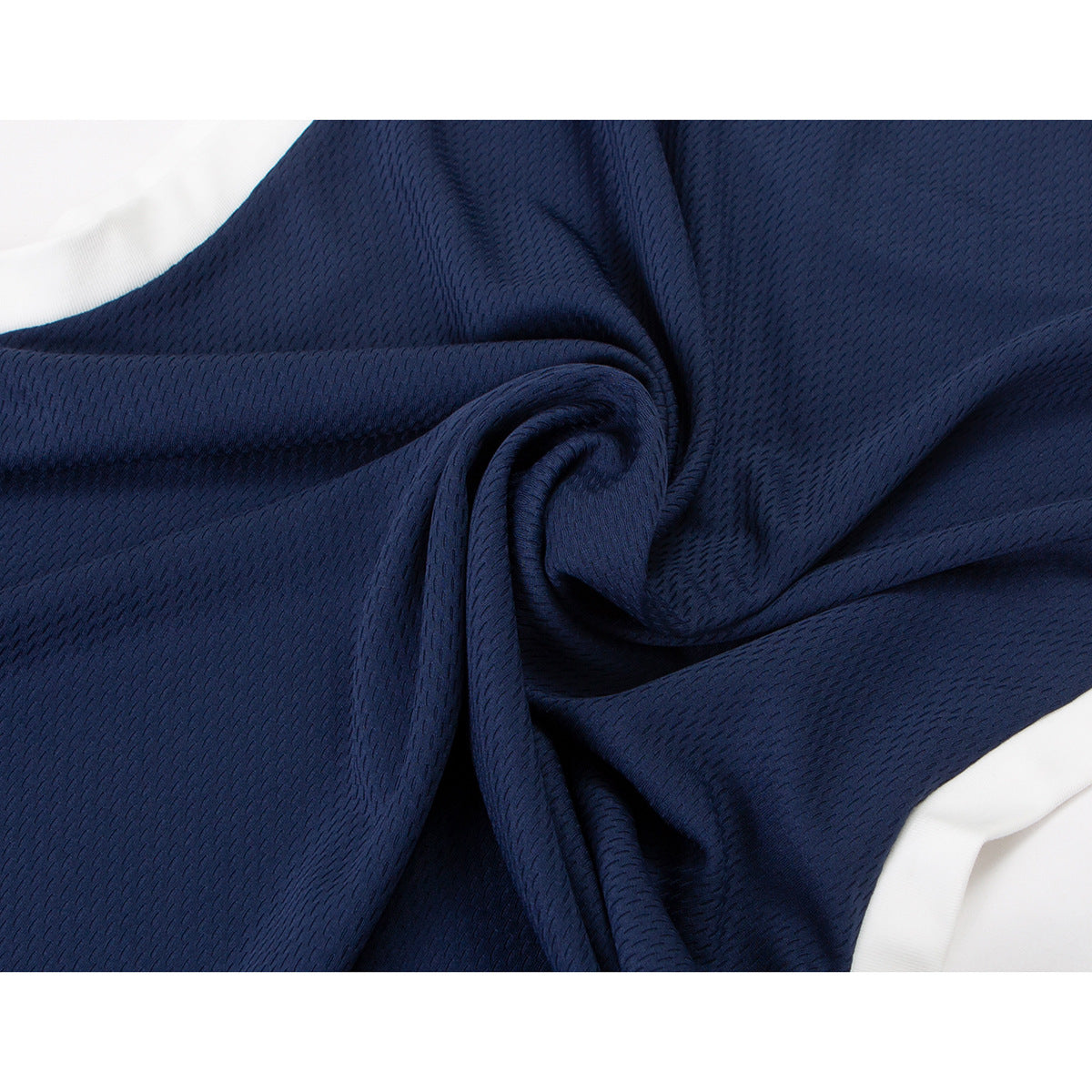 Close-up of gathered navy jersey fabric showing its small textured pattern and white edging.