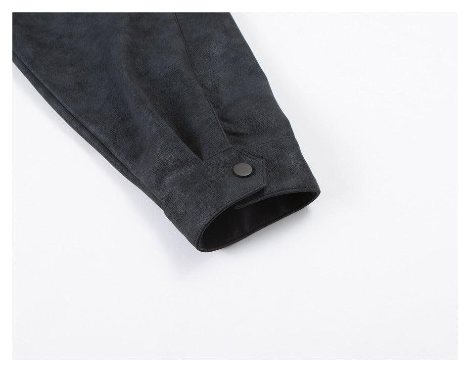 Close-up of a dark jacket sleeve cuff with a round button closure.
