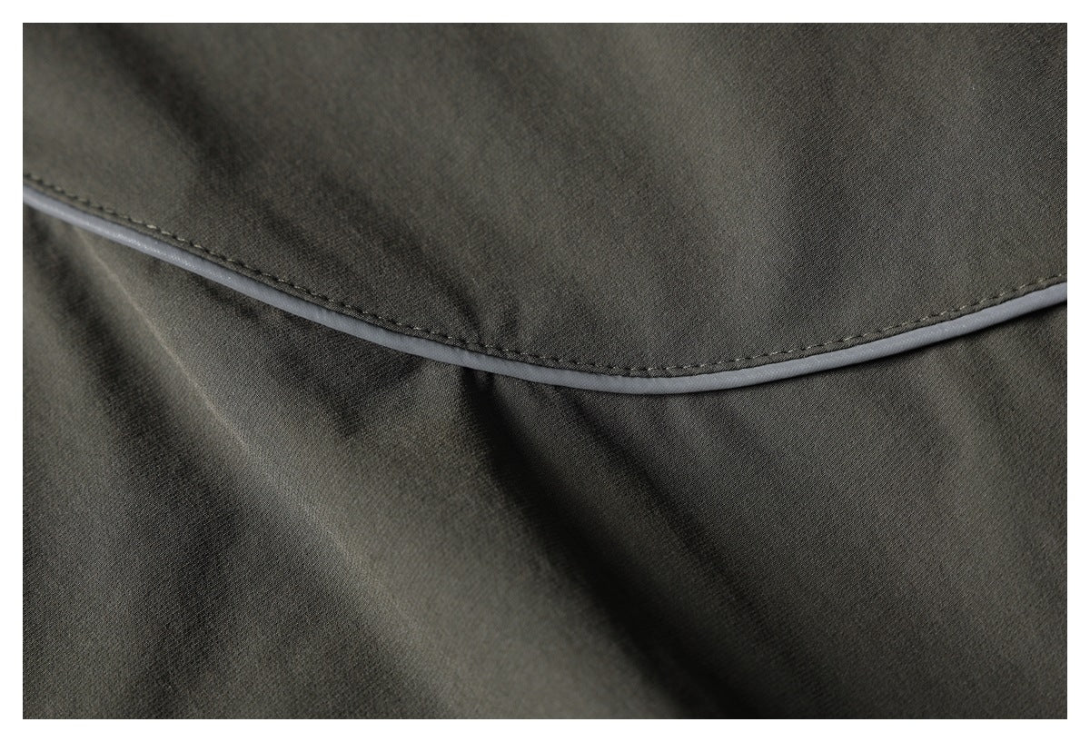 Close-up of dark olive fabric with curved gray piping and visible stitching.