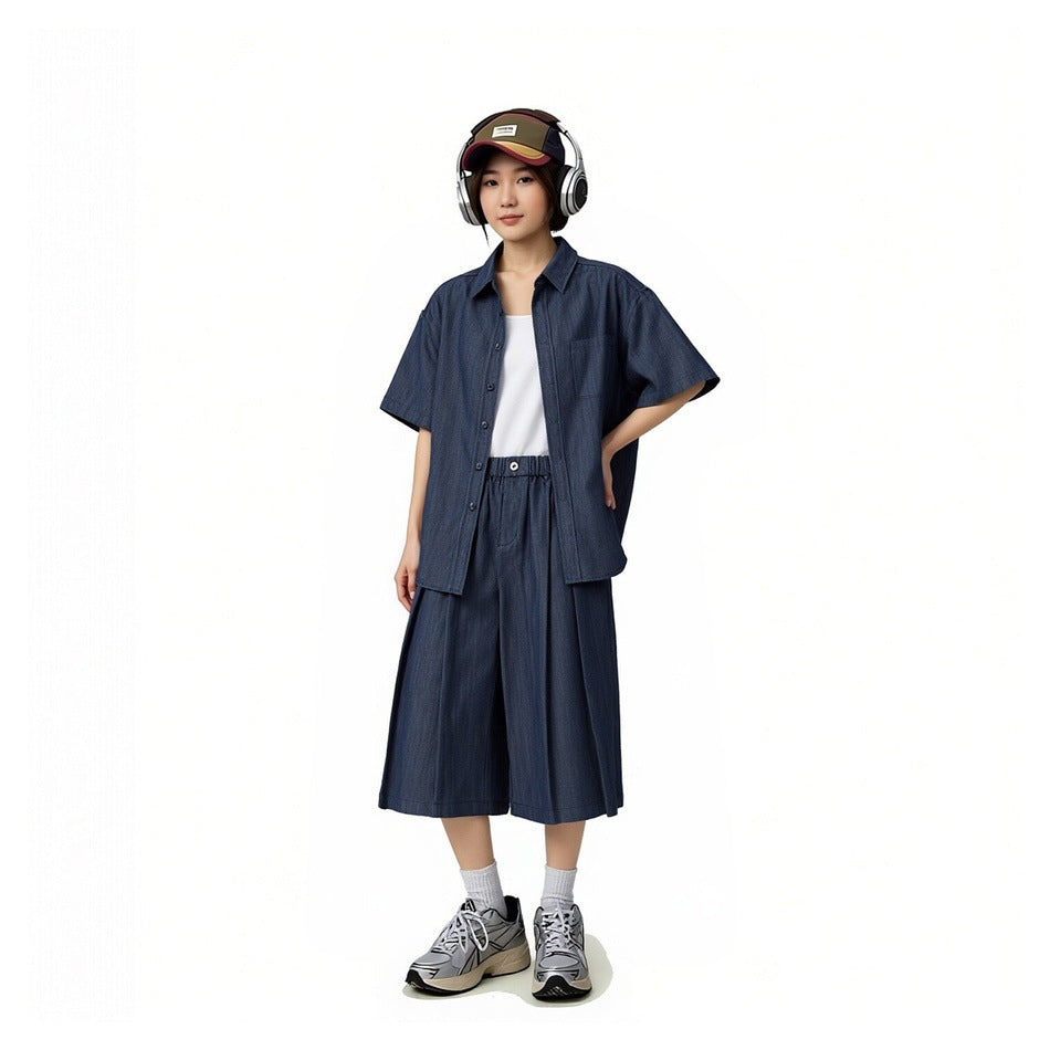 Model wearing an open navy short-sleeve shirt over a white tee with matching wide cropped pants.