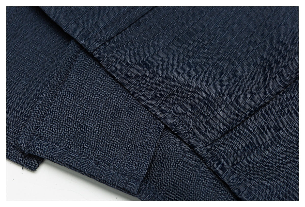 Close-up of stitched seams and folded edges on dark navy fabric.
