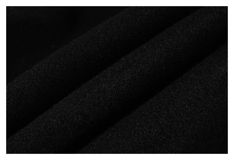 Extreme close-up of black fabric arranged in soft folds, showing its subtle surface texture.