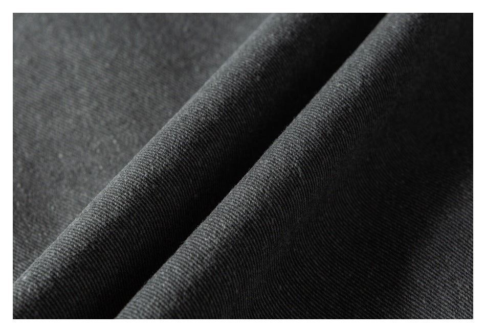 Macro view of dark gray twill fabric arranged in a raised fold.