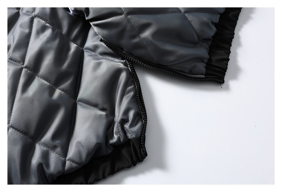 Close-up of a gray quilted jacket with a black zipper along the side opening.