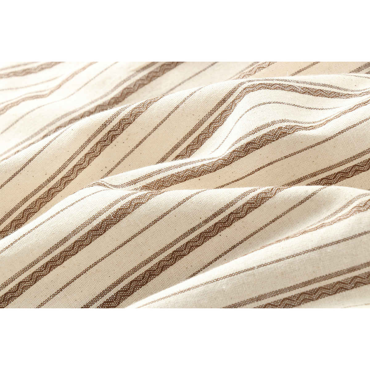 Close-up of cream fabric with textured brown stripes and soft folds.