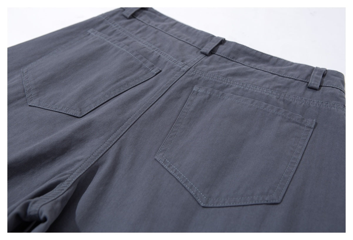 Close-up of the back of charcoal-gray trousers with two patch pockets and belt loops.