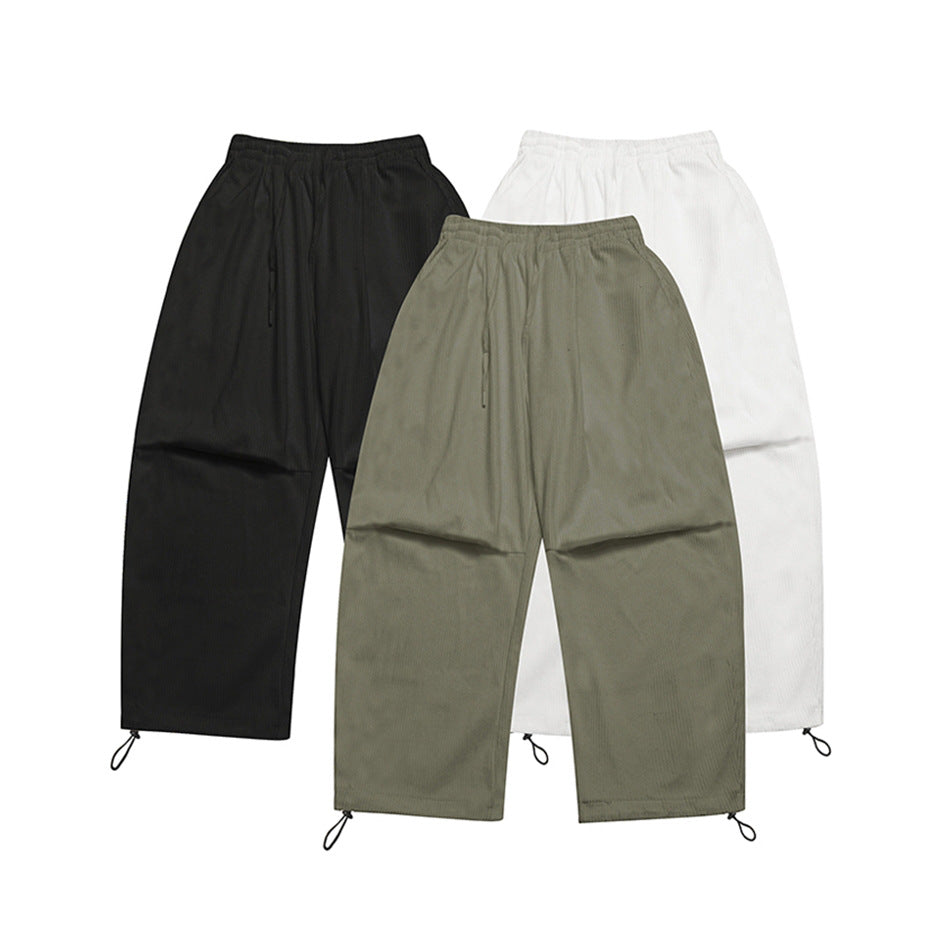 Three pairs of loose ribbed pants shown together in black, olive gray, and white, with elastic waists and hem cord loops.