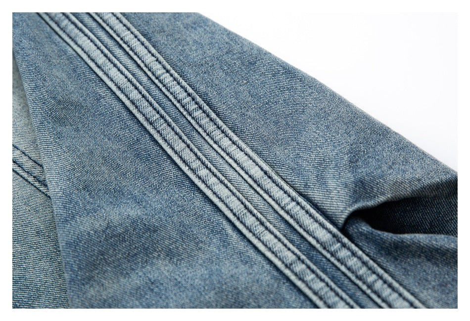 Close-up of blue denim with a prominent diagonal double-stitched seam.