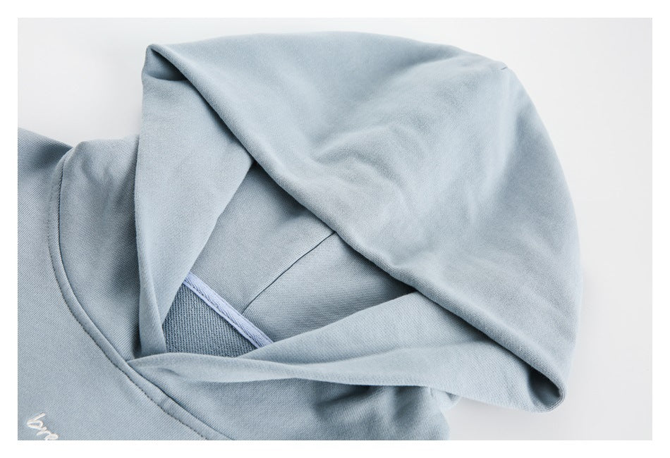 Close-up of the light blue sweatshirt’s hood construction, neckline and inner seam.