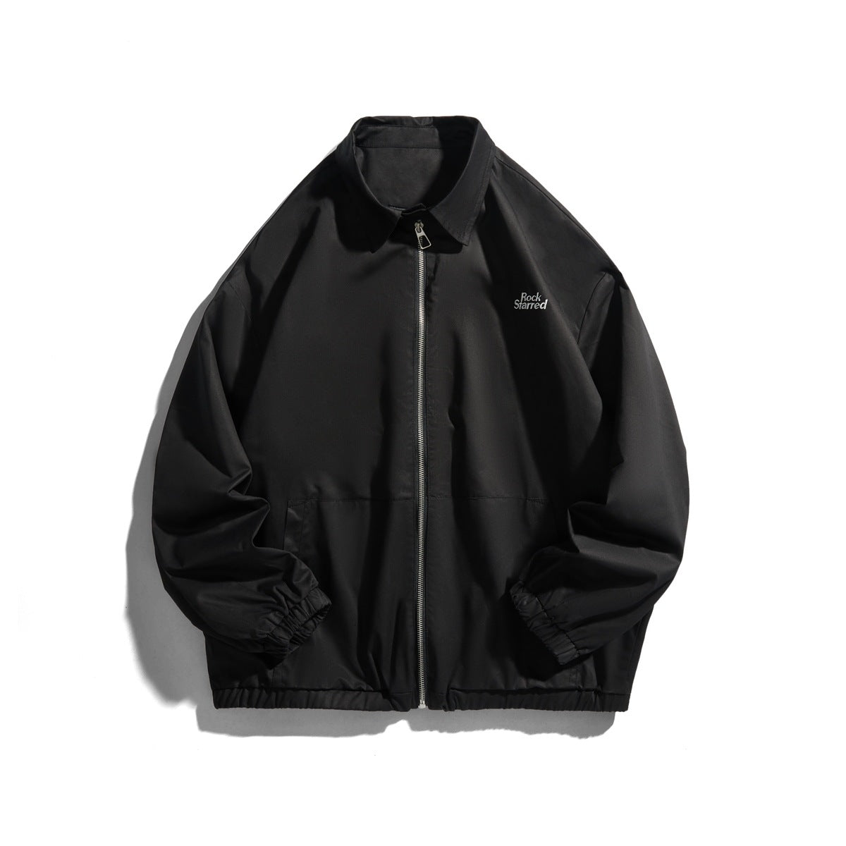 Black zip-front jacket with pointed collar, elastic cuffs and hem, front pockets and a small chest embroidery