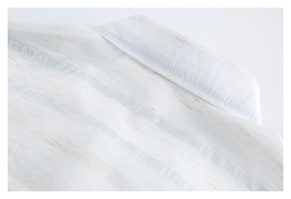 Close-up of white fabric with subtle beige streaks and translucent woven bands.