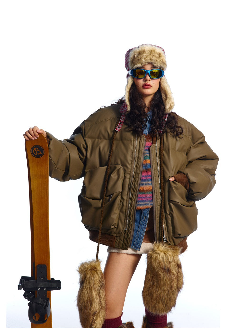 Model wearing an oversized olive-brown padded bomber jacket with large front pockets and brown ribbed trim.