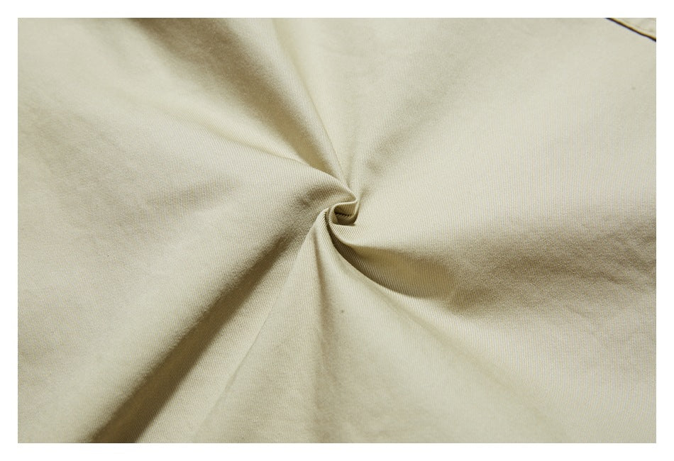 Close-up of beige fabric gathered into a twist, showing its fine texture.