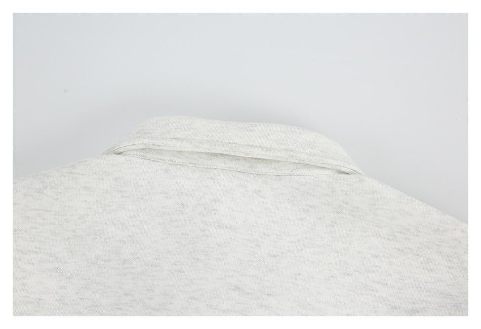 Close-up of the back neckline and shoulder area of a light gray heather sweatshirt.