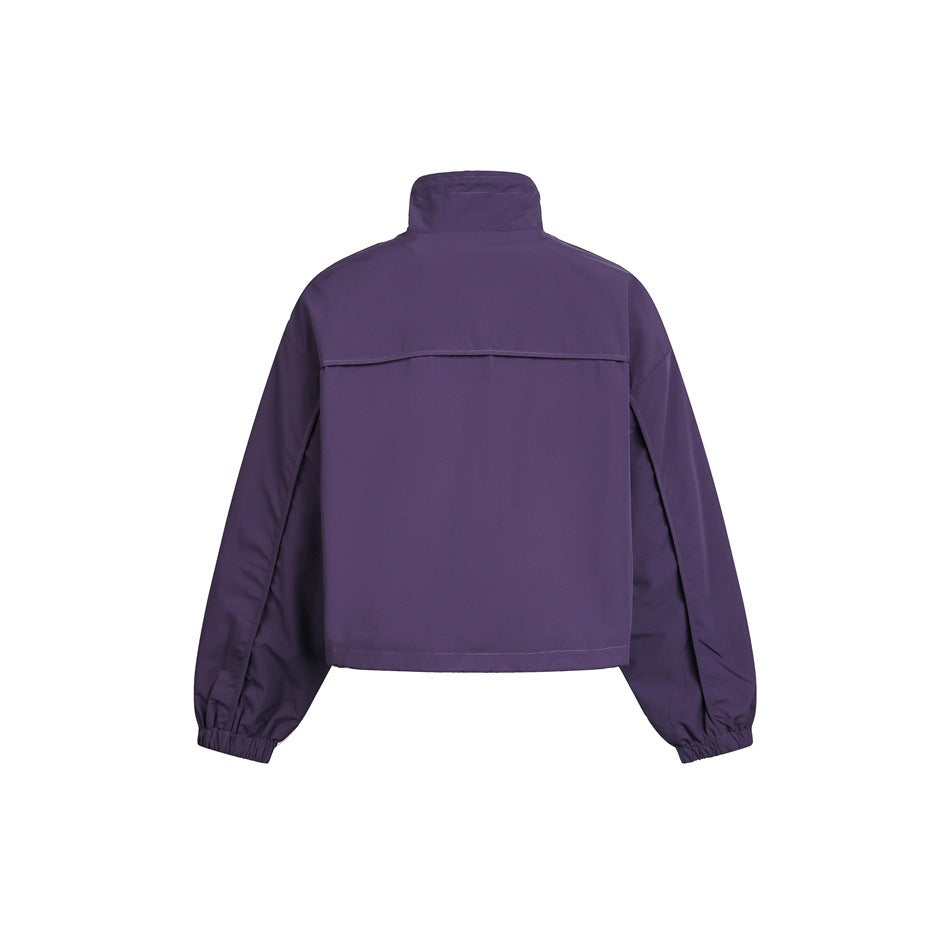 Back view of a dark purple cropped jacket with a high collar, back yoke and elasticated cuffs.