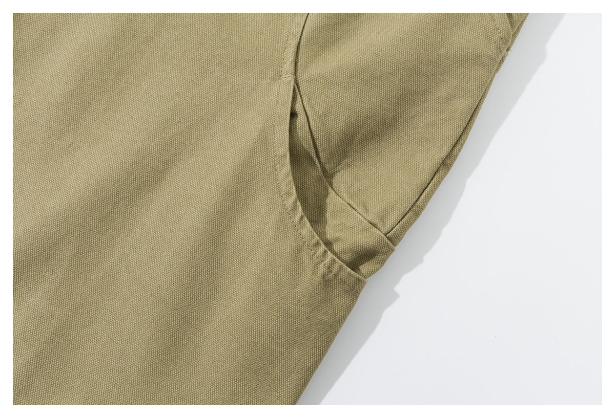 Close-up showing the shorts’ pocket edge, stitching, and textured olive-khaki surface.