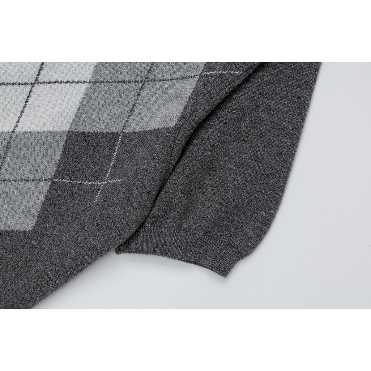 Close-up of the gray argyle polo's short sleeve and dark ribbed cuff.